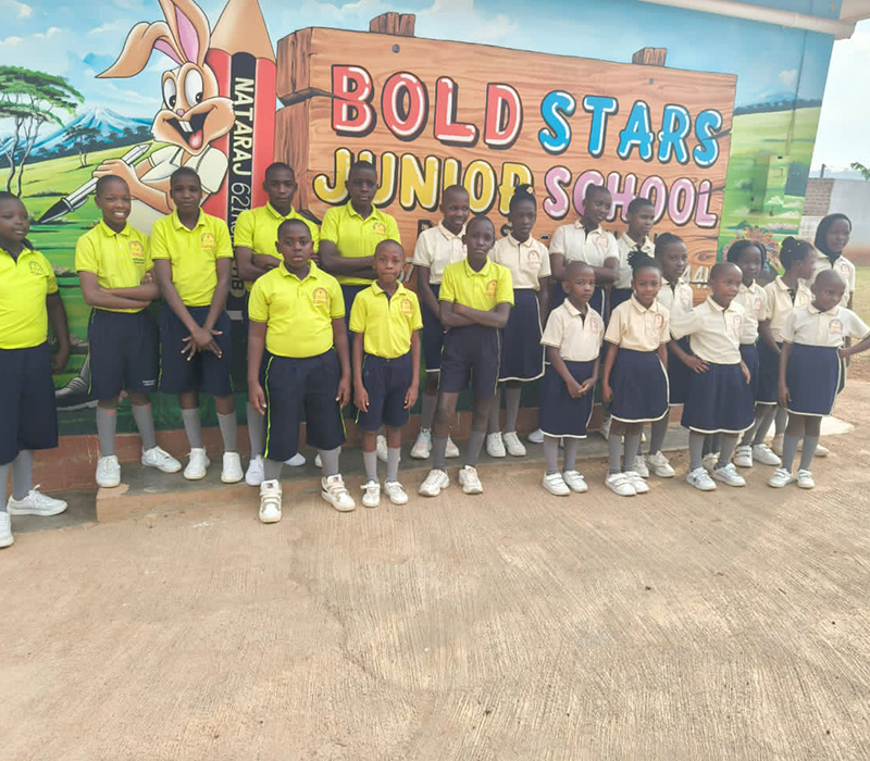  Happy children at Boldstars Junior school standing at the school entrance